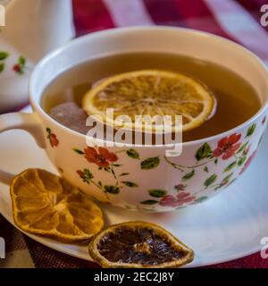 Cup of tea served with dried slices of lemons on the table Stock Photo