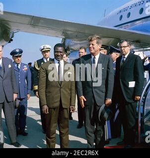 Arrival ceremony for Ahmed Su00e9kou Touru00e9, President of Guinea, 11:00AM. President John F. Kennedy stands with President of Guinea, Ahmed Su00e9kou Touru00e9, upon President Touru00e9u0027s arrival at Washington National Airport. Left to right: U.S. Under Secretary of State, George Ball (partially hidden on edge of frame); Air Force Aide to President Kennedy, Brigadier General Godfrey T. McHugh; Naval Aide to President Kennedy, Captain Tazewell T. Shepard, Jr.; President Touru00e9; unidentified (in back, partially hidden); U.S. Assistant Chief of Protocol for Visits and Public Even