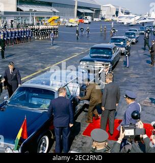 Arrival ceremony for Ahmed Su00e9kou Touru00e9, President of Guinea, 11:00AM. President John F. Kennedy and President of Guinea, Ahmed Su00e9kou Touru00e9 (stepping into car), depart Washington National Airport in the presidential limousine (Lincoln-Mercury Continental convertible with bubble top), following arrival ceremonies in honor of President Touru00e9. Also pictured: Air Force Aide to President Kennedy, Brigadier General Godfrey T. McHugh; White House Secret Service agents, Gerald A. u201cJerryu201d Behn and Bill Greer. Military Air Transport Service (MATS) terminal, Washington N