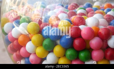 Colorful gumballs in classic vending machine, USA. Multi colored buble gums, coin operated retro dispenser. Chewing gum candies as symbol of childhood