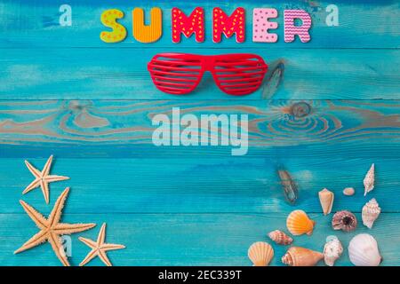 Travel and vacation background with word summer, louvered sunglasses, seashells and sea starfish on blue painted vintage wooden table. Top view with c Stock Photo