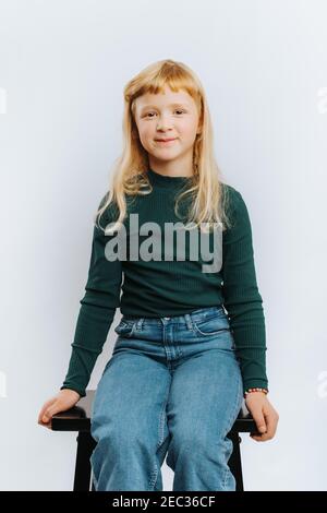 cute blonde girl sitting on steps outdoors thinking Stock Photo - Alamy