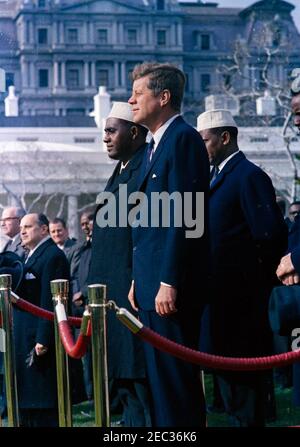 Arrival ceremonies for Abdirashid Ali Shermarke, Prime Minister of the Somali Republic, 11:45AM. Arrival ceremonies for Prime Minister of the Somali Republic, Dr. Abdirashid Ali Shermarke. Standing on reviewing platform in foreground (L-R): Prime Minister Shermarke; President John F. Kennedy; Minister of Foreign Affairs of the Somali Republic, Abdullahi Issa Mohamud; Ambassador of the Somali Republic, Dr. Omar Mohallim Mohamed (mostly hidden on edge of frame). Ambassador of Nicaragua and Dean of the Diplomatic Corps, Dr. Guillermo Sevilla-Sacasa, stands in group left of platform. The Executive Stock Photo