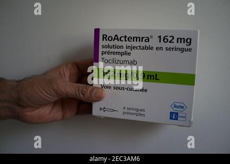 Hand Holding Tocilizumab, RoActemra Medication Box, arthritis drug used in the treatment of Covid-19 Stock Photo