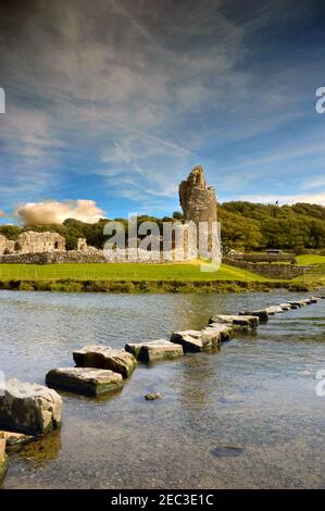 Ogmore, Wales - August 2017: Stepping stones across the River Ogmore with the ruins of the 12th Century castle in the background Stock Photo