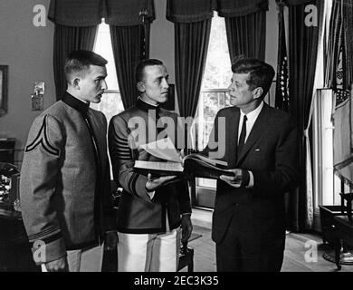 Presentation of the US Military Academy at West Point Yearbook, Howitzer, to President Kennedy, 12:12PM. United States Military Academy cadets of West Point present President John F. Kennedy with a copy of the 1963 u0022Howitzeru0022 yearbook. (L-R) Cadet David W. Knowlton, editor of the yearbook; Cadet First Captain Lyndol L. Cook, class president; and President Kennedy. Oval Office, White House, Washington, D.C. Stock Photo