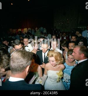 Trip to Western States: Los Angeles, California, Beverly Hilton Hotel, President Kennedy and Jack Benny visit the John Burroughs High School senior prom, 10:22PM. President John F. Kennedy (lower left, with back to camera) greets students from the John Burroughs High School of Burbank, California, during the schoolu0027s senior prom in the Grand Ballroom of the Beverly Hilton Hotel, Los Angeles, California. President Kennedy visited the dance after attending a fundraising dinner at the same hotel. Stock Photo
