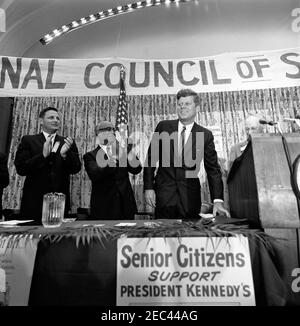 Address to the National Convention of the National Council of Senior Citizens, 11:47AM. President John F. Kennedy attends the National Convention of the National Council of Senior Citizens at the Willard Hotel, Washington D.C. (L-R): Senator Birch Evans Bayh, Jr. of Indiana; Director of Special Projects for the Council, Lawrence A. Oxley; President Kennedy; Council Chairman, John Fitzpatrick (partially hidden behind the lectern). Stock Photo