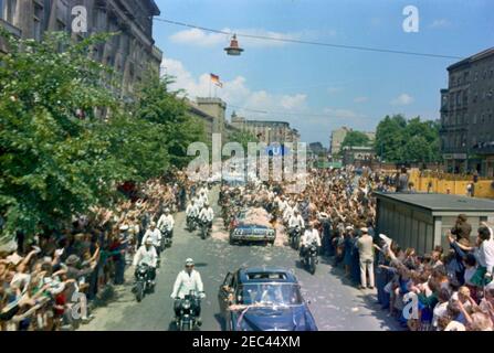 Trip to Europe: Germany, West Berlin: President Kennedy in motorcade with Willie Brandt, Mayor of West Berlin and Konrad Adenauer, Chancellor of West Germany. President John F. Kennedy (in second car) stands in the Presidential limousine (Lincoln-Mercury Continental convertible) as his motorcade travels through West Berlin, West Germany (Federal Republic). Standing with the President: Mayor of West Berlin, Willy Brandt; Chancellor of West Germany, Konrad Adenauer. Crowds line the street, throwing confetti. Stock Photo