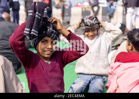 GHAZIABAD, UTTAR PRADESH, INDIA - JANUARY 2021 : A portrait of young boy with smile on face with colorful muffler on head. Stock Photo