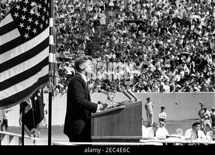 Inspection tour of NASA installations: Houston, Texas, motorcade, address at Rice University, 9:34AM. President John F. Kennedy delivers remarks at Rice University regarding the nationu0027s efforts in space exploration. Members of the press sit at right; spectators observe from the stands. Rice University Stadium, Houston, Texas. Stock Photo