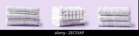 Set of folded white spa towels in stack on light purple background Stock Photo