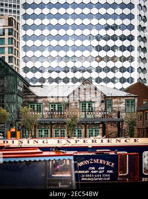 Birmingham Canal House Bar Restaurant, Wharfside wooden river pub with barges and narrowboats moored in front and modern financial district buildings Stock Photo
