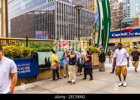 A group of Asian missionaries preaching with a cross and signs written 'Jesus is savior' on them at the entrance of Madison Square Garden Stock Photo