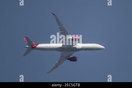 London, UK. 13 February 2021. Air traffic over London during the Covid-19 pandemic. Virgin Atlantic Boeing 787 Dreamliner ‘Birthday Girl’ G-VNEW flies over Wimbledon after leaving London Heathrow en route to Islamabad in hazy afternoon sky. Credit: Malcolm Park/Alamy. Stock Photo