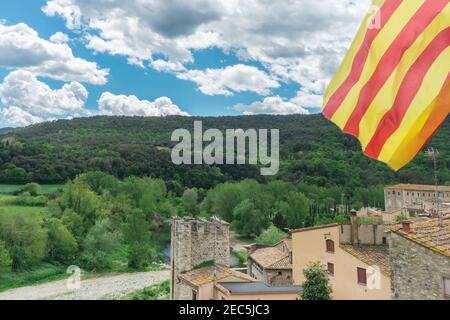 Besalu, Spain - April 26 - 2019: Catalan flag over nice view of Besalu, medieval village in Girona province in Catalonia, Spain. Symbol of aspiration Stock Photo