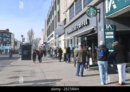 Brighton UK 13th February 2021 - Shoppers queue to get in the Marks & Spencer store in Western Road Brighton as the governments coronavirus COVID-19 lockdown restrictions continue . The shoppers were believed to be hoping to buy the M&S Valentine meal deal offer ready for Valentines Day tomorrow: Credit Simon Dack / Alamy Live News Stock Photo