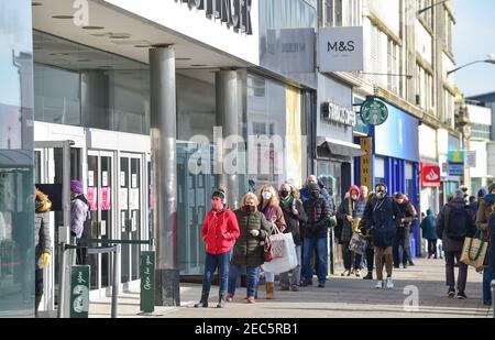 Brighton UK 13th February 2021 - Shoppers queue to get in the Marks & Spencer store in Western Road Brighton as the governments coronavirus COVID-19 lockdown restrictions continue . The shoppers were believed to be hoping to buy the M&S Valentine meal deal offer ready for Valentines Day tomorrow: Credit Simon Dack / Alamy Live News Stock Photo