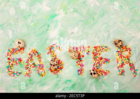 Easter text on a green background with brush strokes with quail eggs. Spring card. Copy space Stock Photo