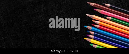 Creative banner with Multicolor pencils on black canvas background, education frame concept with copy space Stock Photo