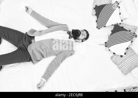 Drained physical and mental resources. One more long day ended. Feel tired and sleepy. Sleepy guy in formal clothes sleep on bed. Lack of sleep. Need more sleep. Evening time. Businessman exhausted. Stock Photo