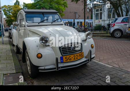 A white citroen 2 CV on the streets of Amsterdam, Netherlands. Historic cult design car. Citroën 2 CV is a low-cost car produced by the French brand. Stock Photo