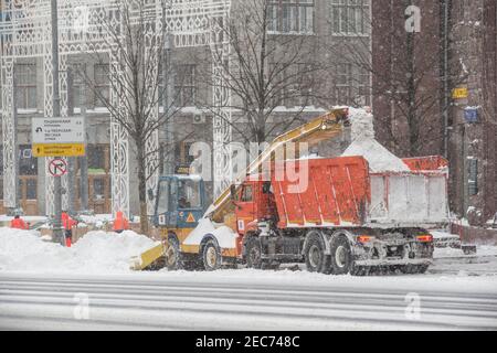 Moscow, Russia, February 13, 2021: A snowplow cleans the street after a severe blizzard. Stock Photo