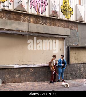 Two girls and a dog hanging on the street Stock Photo