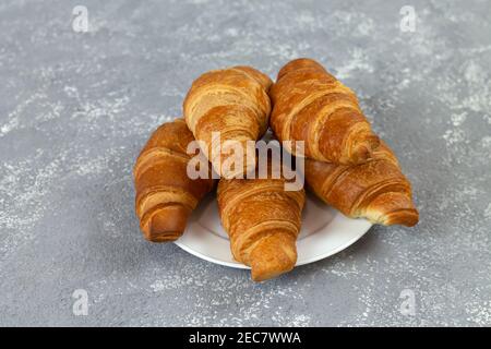 Fresh French croissants on gray stone table Stock Photo