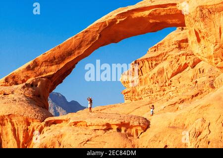 Hiking at rock-arch Al Kharza or Al Borg Alsagheer Wadi Rum, Jordan Stock Photo