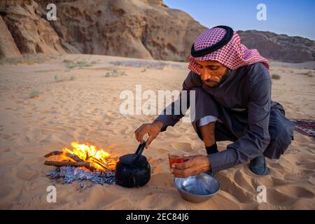 Bedouin making tea on open fire in the desert of Wadi Rum, Jordan Stock Photo