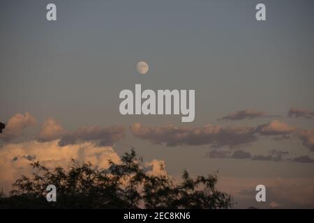 Distant waning moon and clouds Stock Photo