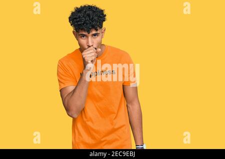 Young arab man wearing tshirt with happiness word message feeling unwell and coughing as symptom for cold or bronchitis. health care concept. Stock Photo