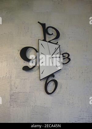 Vertical shot of clock on the wall with large three, six, nine and twelve numbers Stock Photo