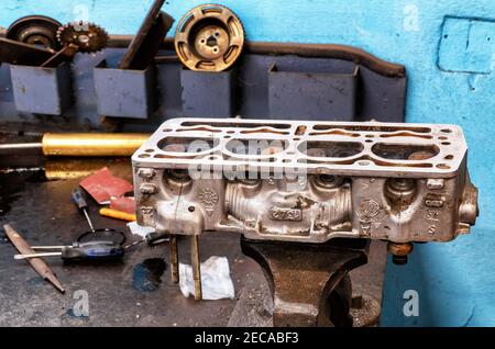 The old car is being repaired. The machine has been lifted to inspect