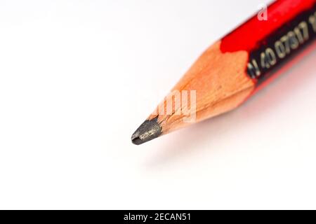 Close up of the point of a single HB pencil lying diagonally on a piece of white paper. Stock Photo