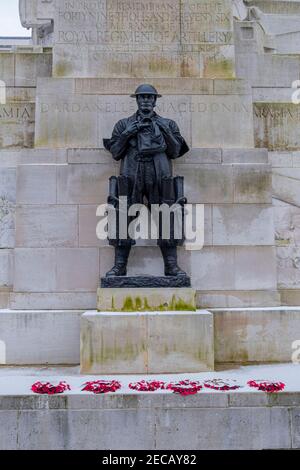 Bronze figure of a standing soldier on the Royal Artillery Memorial with poppy wreaths and snow, Hyde Park Corner, London, UK Stock Photo