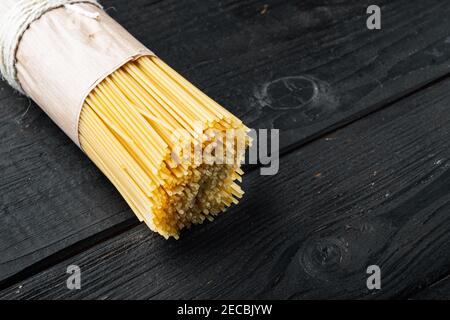 Long spaghetti. Raw spaghetti set, on black wooden table background , with copyspace and space for text Stock Photo