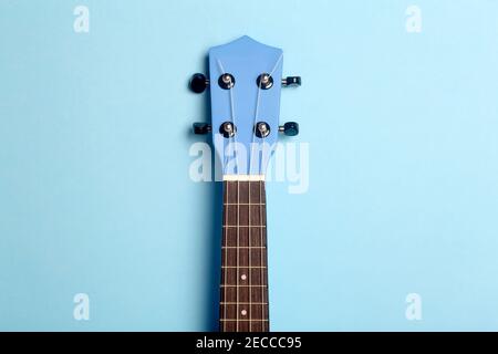 Guitar ukulele on a blue background. Music playing guitar concept. Stock Photo