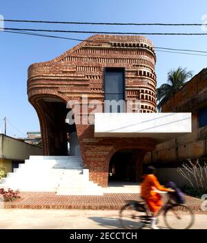 Exterior facade front view with passing girl on bike. The Gallery House, Bansberia, India. Architect: Abin Design Studio, 2020. Stock Photo