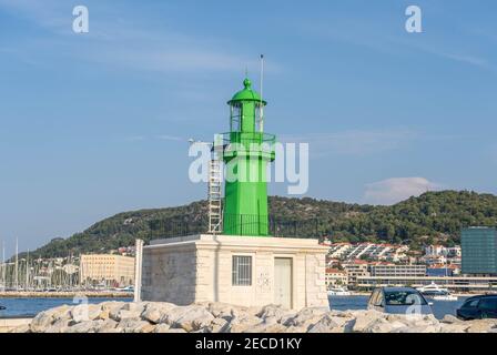 Split, Croatia - Aug 15, 2020: Green lighthouse at old port in early morning Stock Photo