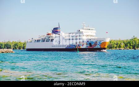 Ms Chi-Cheemaun ferry, decorated with colorful indigenous art on its body, departs Manitoulin Island and sails on the blue water of Georgian Bay, Onta Stock Photo