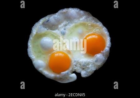 Two fried eggs Isolated on a black background view from above. With clipping path Stock Photo
