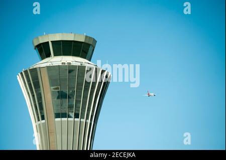 A Shenzhen Airlines aircraft flies past the Air traffic Control tower on departure on a sunny, blue sky, pollution-free day at Beijing Capital Airport, in the Shunyi district of the Chinese capital, Beijing, China, PRC. © Time-Snaps Stock Photo