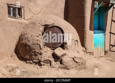 Horno - mud adobe outdoor oven in Southwestern US Pueblo community with old metal barrel top protecting the opening - common in all Spanish-occupied l Stock Photo