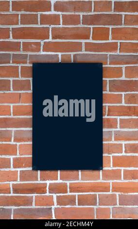 red brick wall with black signboard. artificial stone of regular shape, used as a building material.  Stock Photo