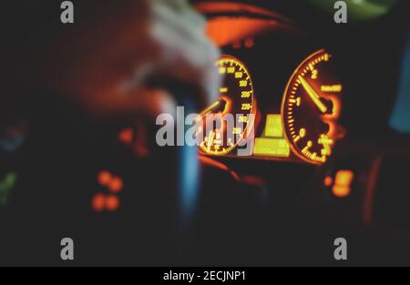 Vienna Austria Dec.2020, Night shot of car Dashboard speedometer with blurred mans hand on steering wheel Stock Photo