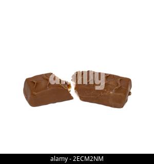 Tasty chocolate bar split in two pieces isolated on white background. Delicious caramel cream and peanuts inside Stock Photo