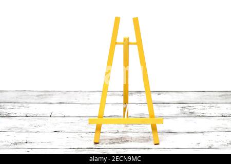 Wooden small easel on a white grunge wooden table Stock Photo