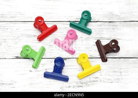 Colorful paper clips on white grunge wooden table Stock Photo